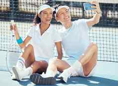 自拍体育夫妇坐着网球法院休息锻炼实践培训健康健身健康跨种族男人。女人体育运动球拍采取电话图片