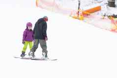 可爱的女孩学习骑孩子们的滑雪板冬天体育孩子安全活跃的体育