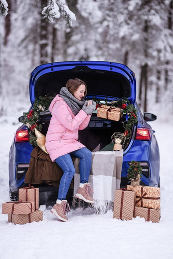 女人冬天衣服饮料热喝<strong>坐</strong>着车装饰一年的<strong>旅行</strong>车森林<strong>旅行</strong>圣诞节