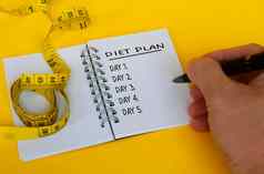 饮食计划文本白色记事本测量磁带黄色的背景健康饮食概念