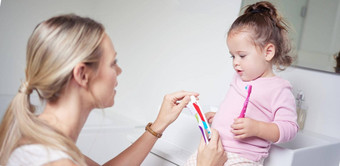 婴儿孩子刷牙牙齿妈妈浴室早....口服卫生清洁牙科医疗保健健康父牙膏牙刷教学年轻的蹒跚学步的女孩孩子健康的口清洁