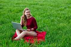 年轻的成功的女人坐着绿色草移动PC手工作自然学生女孩工作隐蔽的的地方业务的想法