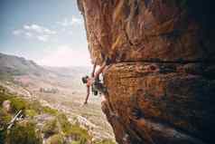 岩石攀爬绳子无所畏惧的山登山者悬崖大岩石有风险的挑战夏天登山抱石强大的男人。培训身体平衡在户外自然
