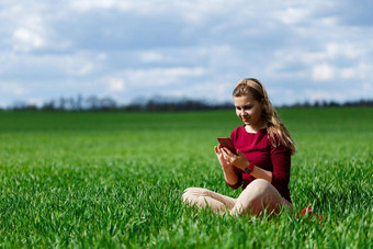 年轻的美丽的女人学生电话手坐着草女孩需要自拍需要自拍图片微笑享受<strong>温暖</strong>的一天概念<strong>照片</strong>智能手机