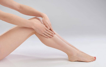 软婴儿皮肤裁剪图像女人触碰光滑的腿