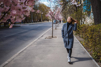 樱花分支机构花树城市街道快乐女人女孩灰色的调色板走小巷盛开的樱花华丽的花俏的女孩在户外樱花树盛开的