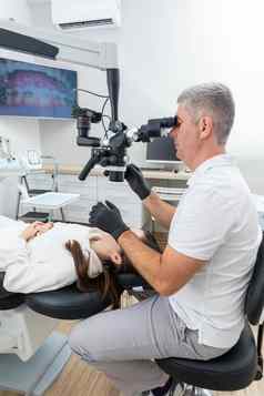 牙医牙科显微镜治疗病人牙科诊所办公室医学牙科健康护理概念