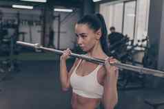 年轻的女运动员锻炼杠铃健身房