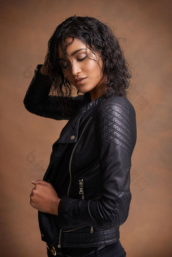 皮革风格工作室拍摄有吸引力的年轻的女人皮革夹克棕色（的）背景
