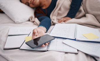 电话书睡觉女人学生累了学习研究教育考试纸床上大学大学女孩休息移动智能手机在线研究文书工作文档