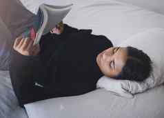 女人学生阅读书卧室放松学习研究首页年轻的少年大学女孩人休息书床上教育知识小说故事