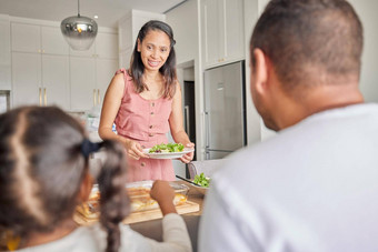 健康的素食主义者妈妈。家庭沙拉午餐餐吃厨房表格首页妈妈爸爸孩子自制的食物绿色蔬菜零食健康生活方式