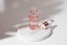 粉红色的玻璃瓶化妆品液体透明的过来这里白色背景下降瓶透明质酸酸石油血清皮肤护理产品