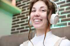 肖像微笑年轻的高加索人女人耳机会说话的视频调用首页照片快乐女人耳机相机虚拟谈话网络摄像头会议