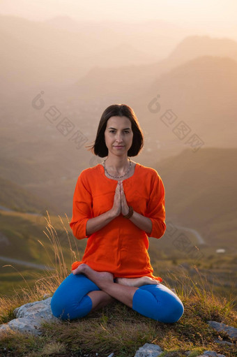yogini莲花位置完整的脸坐在悬崖背景日落天<strong>空山</strong>祈祷