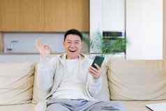 快乐年轻的亚洲男人。首页手机情感赢家胜利金融促销活动体育押注男人。幸福的惊呼道玩游戏兴奋快乐庆祝成功
