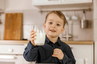 男孩坐着厨房喝牛奶新鲜的牛奶玻璃乳制品健康的喝医疗保健源钙乳糖舒适的现代室内学前教育孩子休闲服装