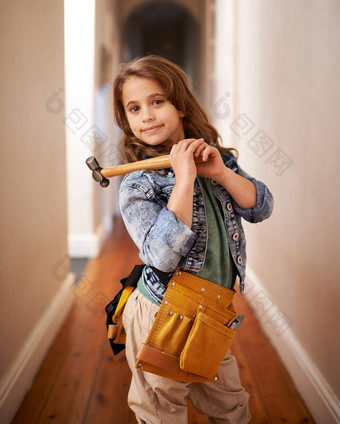 修复肖像年轻的女孩穿工具带持有锤