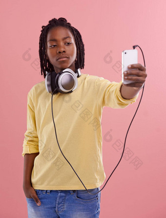 时间快速图片年轻的男孩耳机脖子采取照片智能手机
