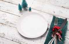 圣诞节表格设置白色餐具银器红色的绿色装饰白色木背景