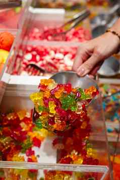 女人手独家新闻采取色彩斑斓的美味的糖果计数器商店杂货店市场咖啡馆