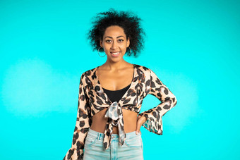 漂亮的非洲女人非洲式发型头发豹前微笑相机蓝色的墙背景可爱的混合比赛女孩的肖像