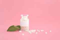 特写镜头图像顺势疗法球玻璃瓶柔和的粉红色的背景顺势疗法药店Herbal自然医学替代顺势疗法医学医疗保健免费的空间复制空间