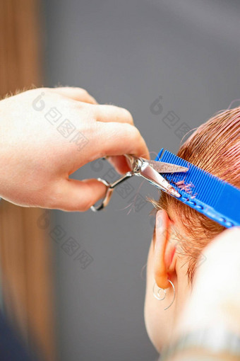 专业发型师切割短粉红色的头发剪刀头发沙龙关闭