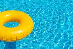 黄色的环浮动让人耳目一新蓝色的游泳池