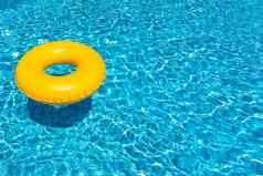黄色的环浮动蓝色的游泳池充气环休息概念
