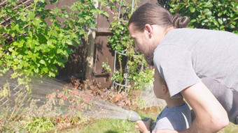 父亲儿子有趣的男孩浇水草坪上植物花园住房后院爸爸夏天房子工作勤劳的学前教育孩子在户外孩子们做家务活动孩子们