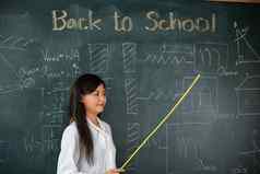 亚洲女老师微笑木坚持指出黑板上