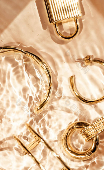 金手镯耳环环Jewelery黄金水背景奢侈品魅力假期美设计珠宝品牌广告