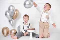 男孩庆祝生日孩子们生日聚会，派对生日蛋糕蜡烛气球快乐孩子们庆祝活动白色极简主义室内