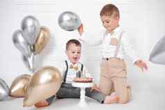 男孩庆祝生日孩子们生日聚会，派对生日蛋糕蜡烛气球快乐孩子们庆祝活动白色极简主义室内