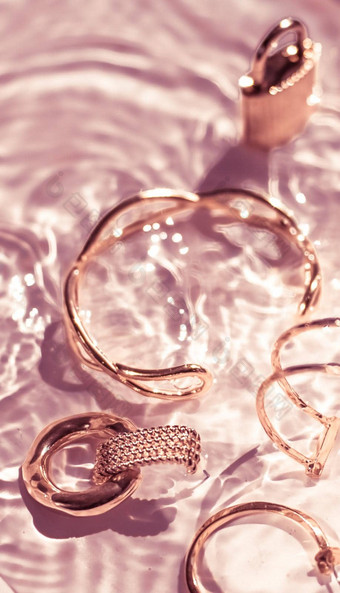 玫瑰黄金手镯耳环环Jewelery粉红色的水背景奢侈品魅力假期美设计珠宝品牌广告