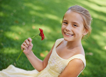 美丽的花美丽的女孩肖像美丽的女孩持有坐着草美丽的红色的花