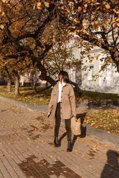 时尚的浅黑肤色的女人女人走秋天城市季节秋天