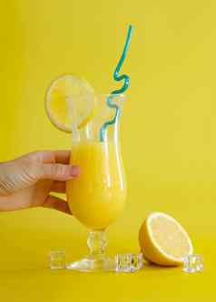 新鲜的橙色汁玻璃装饰片柠檬蓝色的稻草夏天鸡尾酒黄色的背景色彩斑斓的设计