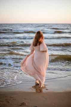 年轻的女人美丽的海视图背景女人长头发粉红色的衣服坚定海滩浪漫的视图海洋日落放松sekective焦点