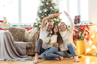 美丽的年轻的家庭享受<strong>假期</strong>时间装修圣诞节树<strong>安排</strong>圣诞节灯有趣的