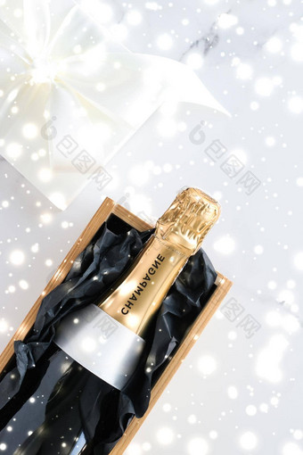 圣诞节假期香槟瓶礼物盒子闪亮的雪大理石背景