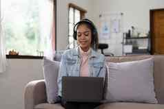 年轻的女人坐着沙发首页视频调用聊天朋友移动PC首页