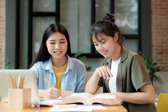 年轻的亚洲学生校园帮助朋友捕捉学习