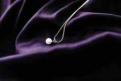 奢侈品白色黄金珍珠项链黑暗紫罗兰色的丝绸背景假期魅力Jewelery现在