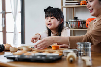 年轻的女孩妈妈。万圣节使<strong>对待</strong>蛋糕表格快乐万圣节一天