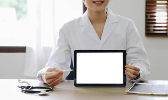 肖像有经验的医生女人心脏病专家现在现代技术白色屏幕平板电脑咨询病人穿白色外套统一的听诊器检<strong>查房</strong>间