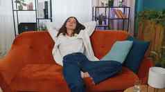 累了年轻的女人说谎沙发上采取休息首页打盹下降睡着了橙色沙发上
