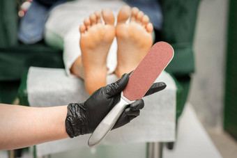 特殊的刨丝器擦洗高跟鞋手指甲修脚技术员脚背景美沙龙特写镜头