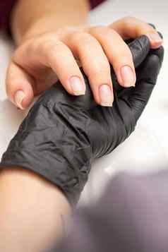检查修剪整齐的指甲手修指甲主黑色的手套检查女透明的指甲修指甲沙龙